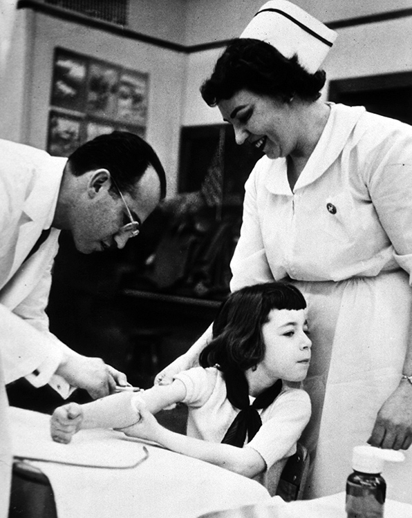 Jonas Salk inoculating a young girl